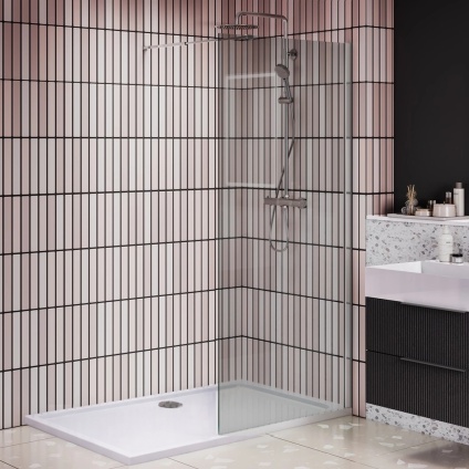 lifestyle image of apex single panel shower enclosure in chrome with shower tray and waste in black and white metro tiled bathroom